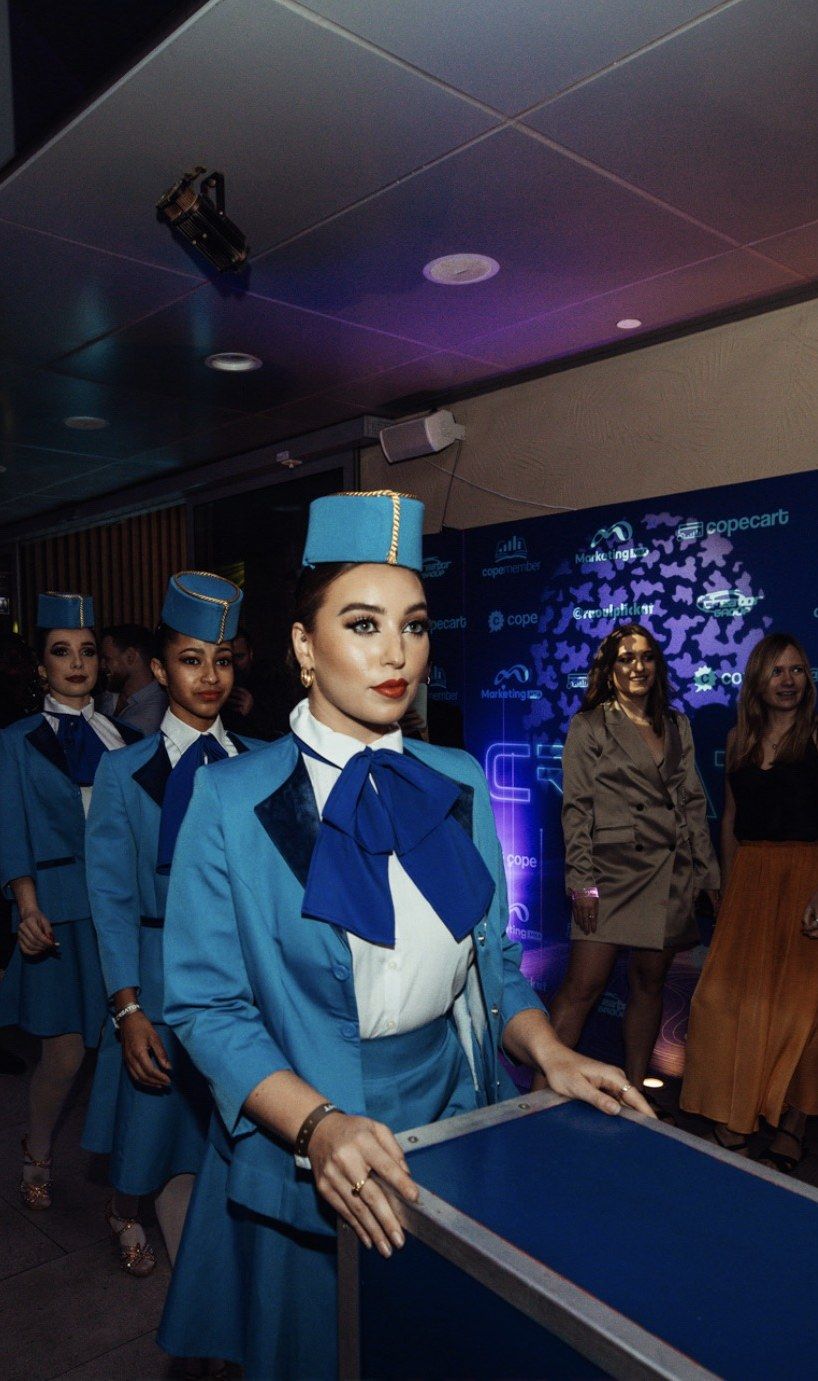 Dancers dressed as flight attendants leading guests to Nonya