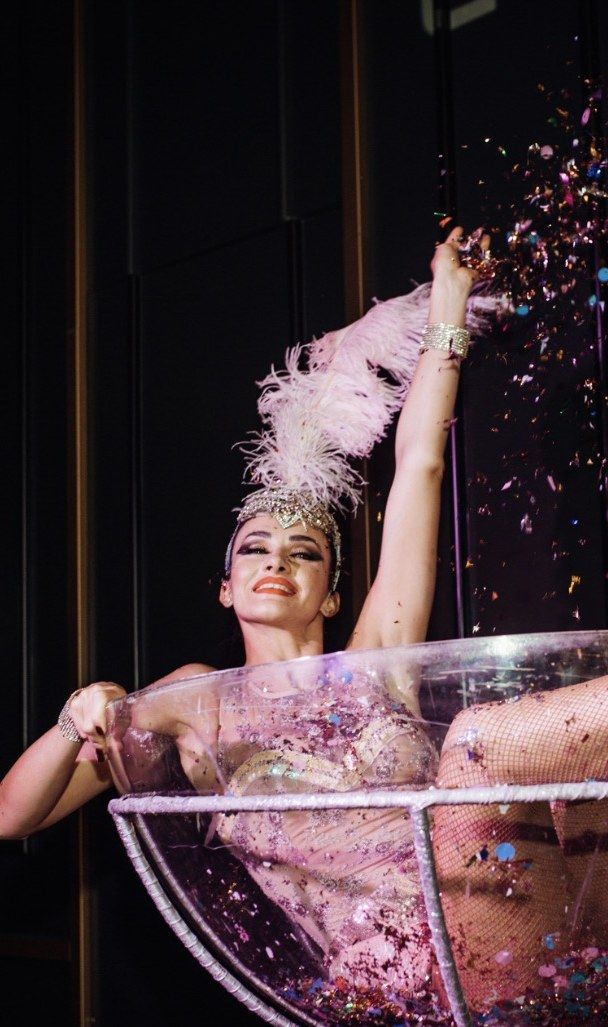 Showgirl throwing confetti from a giant martini glass at Creator Night